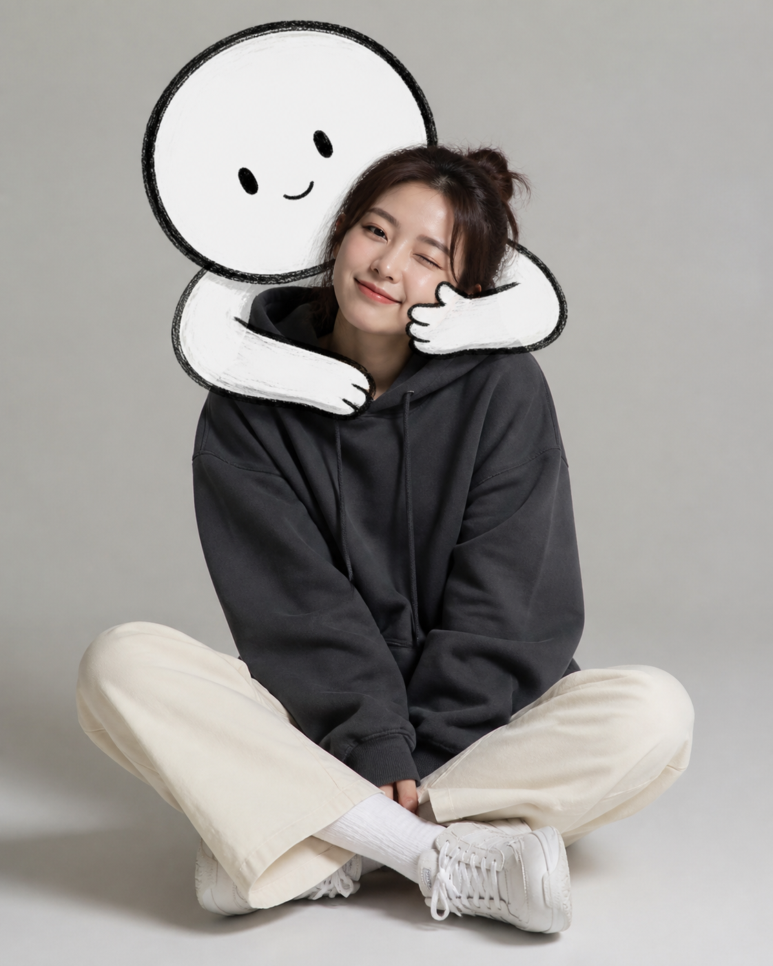 A seated woman smiles as a simple black-and-white doodle character hugs her shoulders.